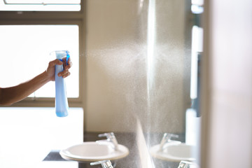 Worker using detergent spray bottle