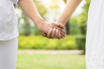 Elderly and woman holding hands together,Take care and support