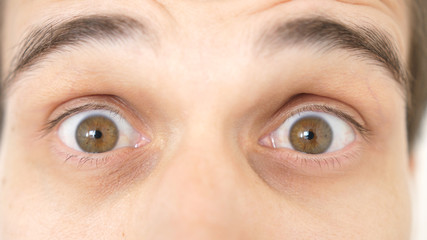 Close-up of a surprised emotional man with brown eyes