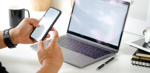 Man using mobile smartphone in office workspace