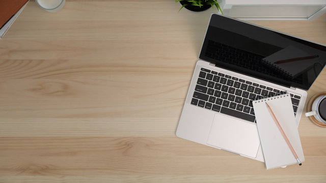 Wood office desk table with laptop, office  supplies and copy space.