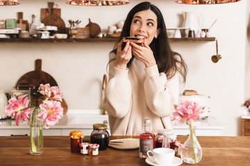 Smiling young girl having tasty breakfast