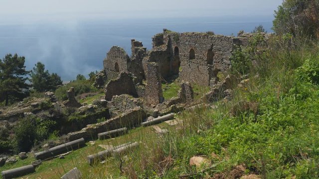 beautiful view of ancient castle ruins with calm Mediterranean sea on background.