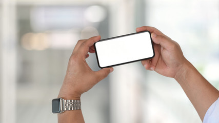 Man and blank screen mobile phone over blurred background