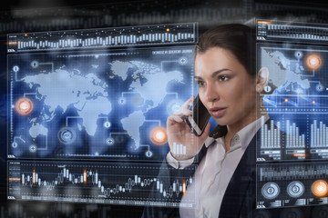 Young business lady speaks on the phone and works in futuristic office