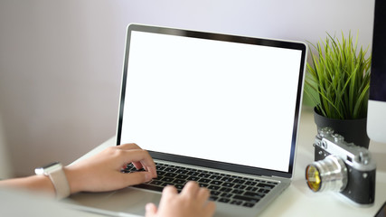 Fototapeta na wymiar Female freelancer typing and using laptop keyboard at her workplace
