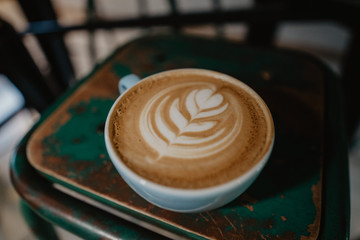 Taza de café en una silla, dibujo corazón latte art