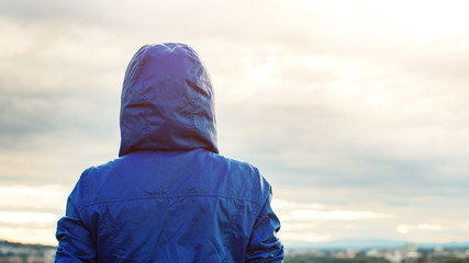 Back view of athlete woman looking sunset over city skyline after exercising. Motivation, sport and...