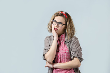 Fototapeta premium Emotional portrait of a fair-haired girl on a gray background, stormy emotions, business concept.