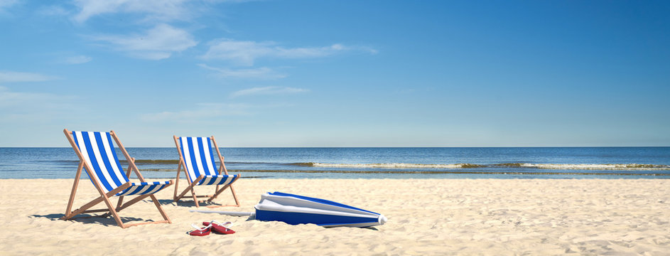 Paar Strand Liegen am Meer mit Sonnenschirm im Sand