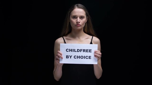 Woman showing childfree by choice sign, voluntary refusal from children, freedom