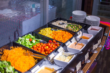 Colorful fresh vegetable salad bar with homemade sauces dressing