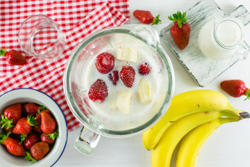 The process of making smoothies of banana, strawberry and milk