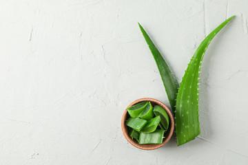 Aloe vera leaves and slices on white table, space for text and top view. Natural treatment