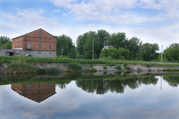 Large brick building near the lake. Reflection in water.