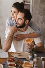 Happy cheerful couple having tasty breakfast