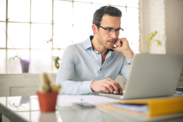 Fototapeta premium Handsome businessman working at the office