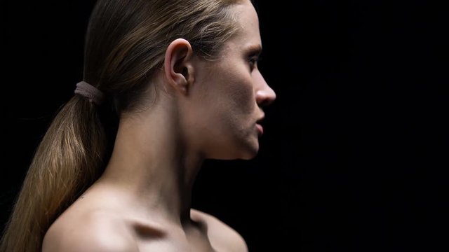 Woman taking off dumb blonde label from ear, protest against stereotype, closeup