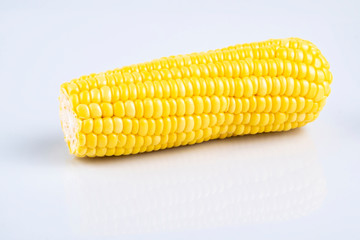 fresh raw sweet corn on the cob kernels over white background