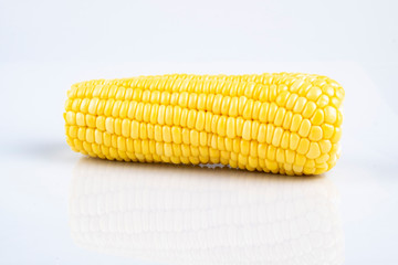 fresh raw sweet corn on the cob kernels over white background