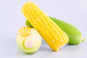fresh raw sweet corn on the cob kernels over white background