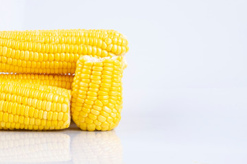 fresh raw sweet corn on the cob kernels over white background