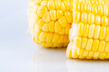 fresh raw sweet corn on the cob kernels over white background