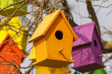 One yellow birdhouse on tree