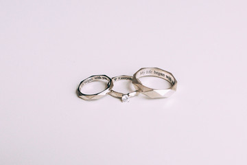 Silver rings of newlyweds with inscriptions on a white background.