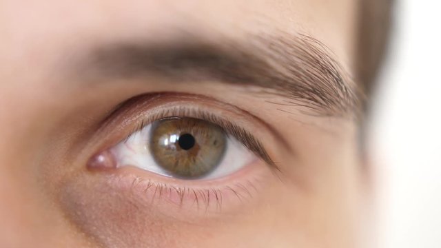 Close up of a male eye. Detail of opening a brown eye of a man looking at camera. slow motion. 3840x2160