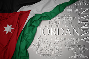 waving colorful national flag of jordan on a gray background with important words about country - obrazy, fototapety, plakaty