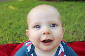 Portrait of a happy baby with big blue eyes in a patriotic outfit