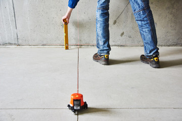 man with laser level check floor and walls
