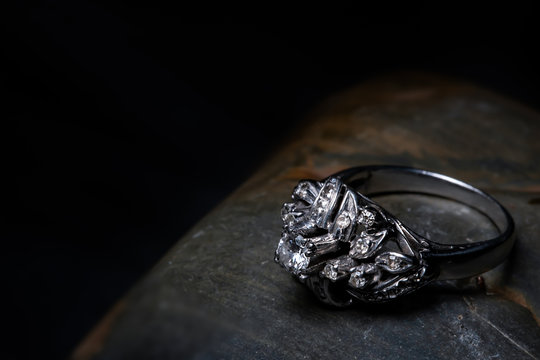 Diamond Ring On A Black Stone With Side Lighting.