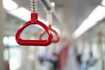 Close up of Hand holding handle on the electric train or subway.