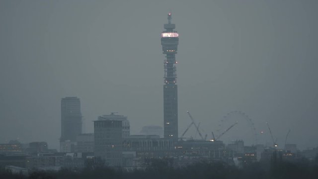 Steady, wide shot of the BT Tower and the London Eye.