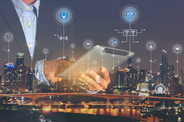 Smart city or Internet of Things (IoT), Double exposure of Businessman hands holding digital tablet...