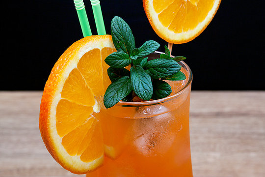 Cocktail. Orange juice with mint rustic wooden table