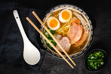 Japanese Ramen Soup with Udon Noodles, Pork, Eggs and Scallion on dark Stone Background - 267979589