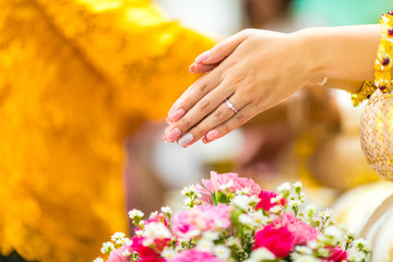 Focus at hand, Thai wedding water pouring from conch shell to bless the bride.