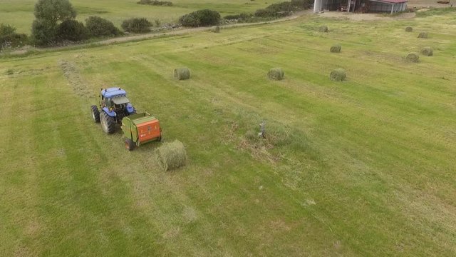 22bird eye of Man at work on the tractor with hay baler