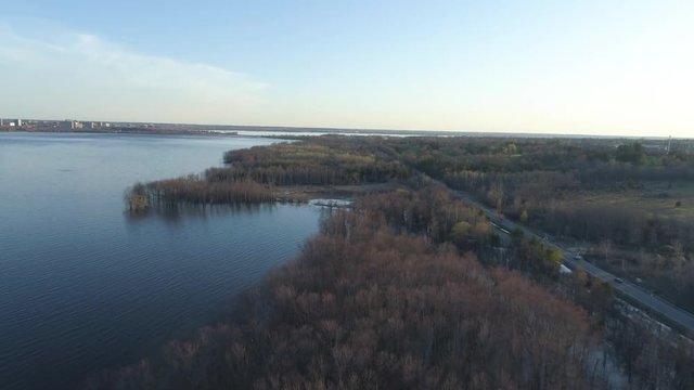 Drone footage over the flooded Ottawa River beside Boulevard de Lucerne at sunset.