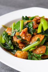 Fried Chinese kale with crispy skin chicken in oyster sauce and chilli in the white dish.