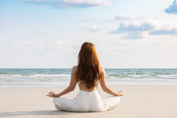 Fototapeta na wymiar Back of views woman practice yoga lotus pose to meditation with summer vacation on the beach feeling so happiness and cheerful,Travel in tropical beach in Thailand,vacations and relaxation Concept