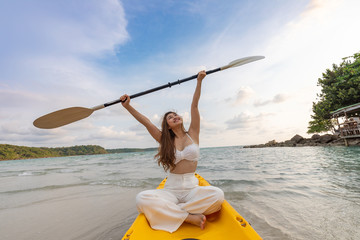 Attractive Asian young woman kayaking enjoy with summer vacation on the beach feeling so happiness and cheerful,Travel in tropical beach in Thailand,vacations and relaxation Concept