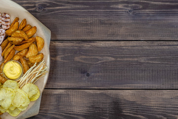 Assorted snacks  on dark wooden background. Empty space for text. Top view