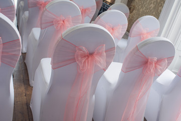 Covered chairs set for a party or wedding with bows