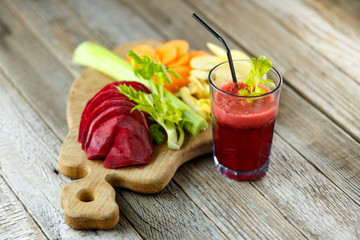 Freshly squeezed vegetable juice for detox. On a wooden board ingredients for making juice. Healthy lifestyle and diet.