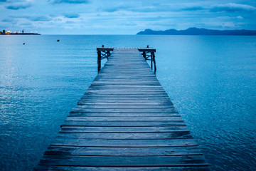 Dark morning by the sea. Pier in storm. Solitude, Loneliness concept photo