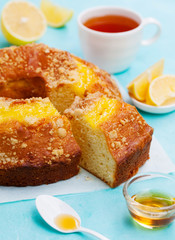 Lemon bundt cake with cup of tea. Blue background. Close up.